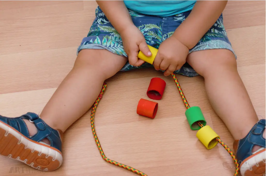 Actividad para niños de un año enhebrar rollos