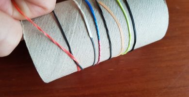 Ensartar gomas de colores en un tubo de cartón